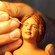 Una mano pintando el rostro de la figura de una mujer
